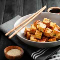 Chrupiące kostki tofu w sosie, pałeczki i sezam. To pyszne danie pokazuje, co to tofu.