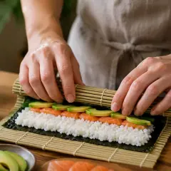 Przygotowanie ryżu do sushi z zaprawą na 500g ryżu. Na macie bambusowej układane są składniki: ryż, łosoś i awokado.
