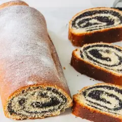Stary przepis na makowiec, który zachwyca wyglądem i smakiem. Rolada z makiem, oprószona cukrem pudrem, prezentuje się apetycznie.