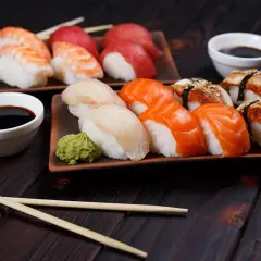 Różnorodne sushi rodzaje: nigiri z krewetką, łososiem, białym rybą i węgorzem, podane z wasabi i sosem sojowym.
