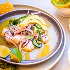 Pyszne ceviche z rybą, awokado, czerwoną cebulą i jalapeno, podane z nachos i limonką.