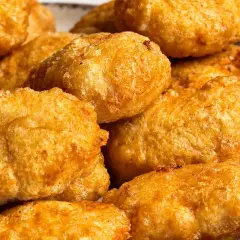 Złociste, chrupiące domowe nuggetsy jak z McDonald's, ułożone na talerzu. Idealne na szybką przekąskę.