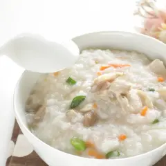 Miseczka pysznego congee z kurczakiem i warzywami, gotowa do spożycia.