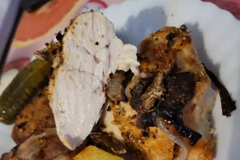 Soczyste, przyprawione **piersi z kurczaka air fryer** z chrupiącymi ziemniakami i ogórkiem kiszonym.