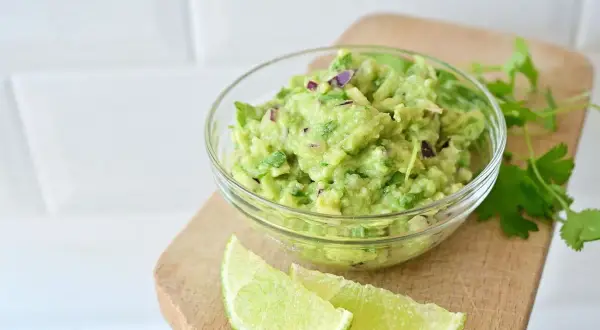 Świeże guacamole z awokado, cebuli i kolendry. Idealny przepis na guacamole, podane z limonką.