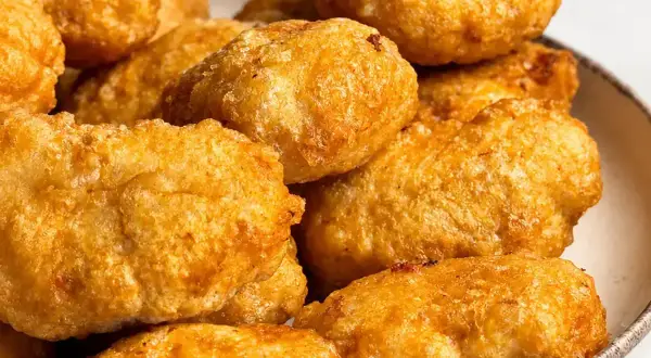 Złociste, chrupiące domowe nuggetsy jak z McDonald's, ułożone na talerzu. Idealne na szybką przekąskę.