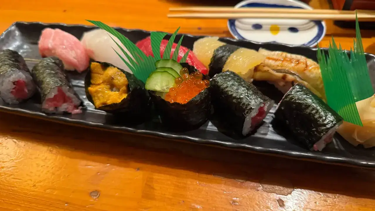 Różnorodne sushi rodzaje: maki z tuńczykiem, nigiri z łososiem i białą rybą, gunkan z jeżowcem, ikrą i ogórkiem, oraz unagi.