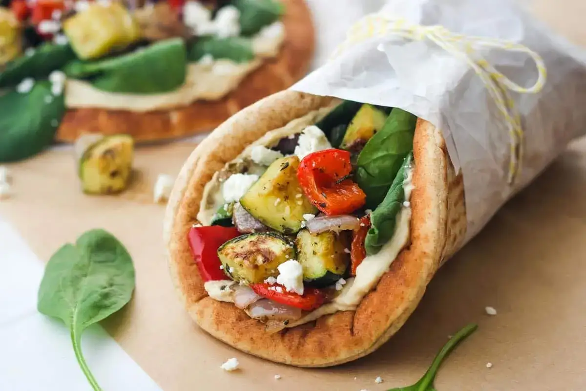 Pyszny wrap z warzywami i fetą, wypełniony kremowym hummusem. To właśnie jest hummus!