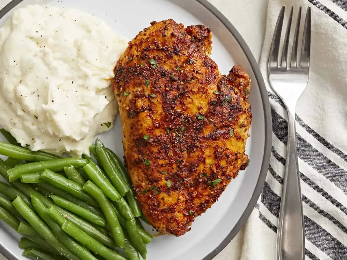 Pyszny piers z kurczaka air fryer, podany z kremowym purée ziemniaczanym i zieloną fasolką szparagową.