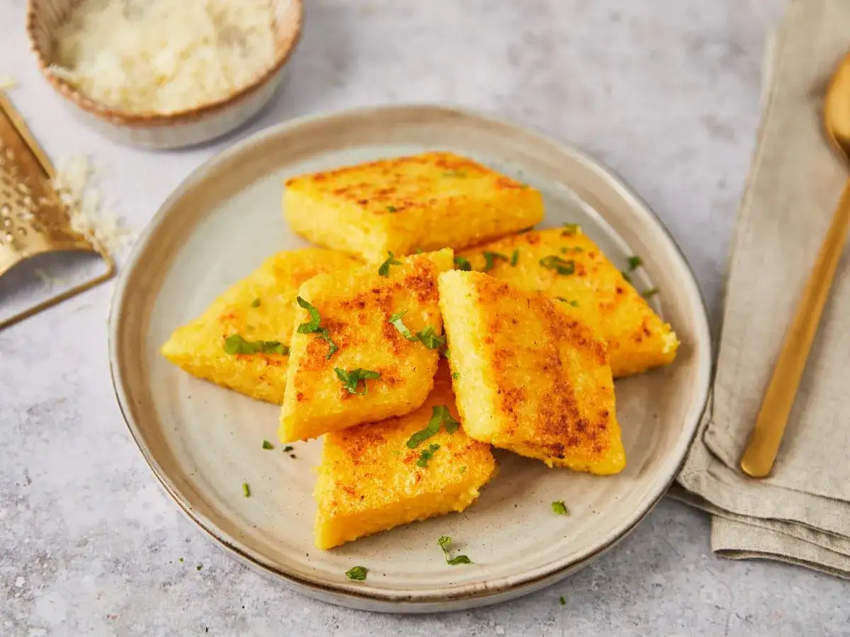 Usmażone kawałki polenty, posypane natką pietruszki. To właśnie polenta co to za danie!