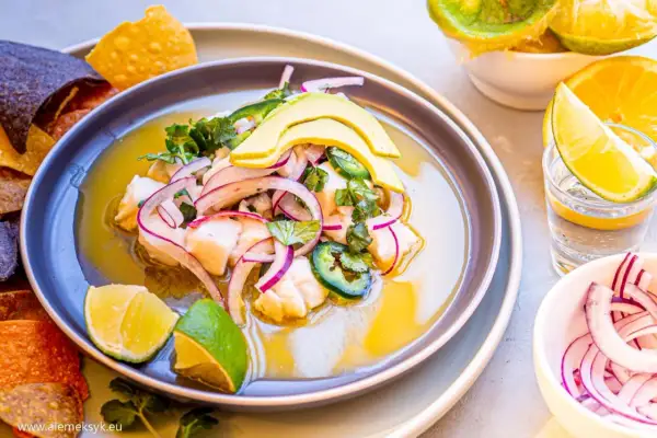 Pyszne ceviche z rybą, awokado, czerwoną cebulą i jalapeno, podane z nachos i limonką.