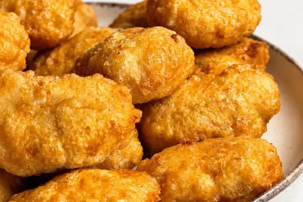Złociste, chrupiące domowe nuggetsy jak z McDonald's, ułożone na talerzu. Idealne na szybką przekąskę.